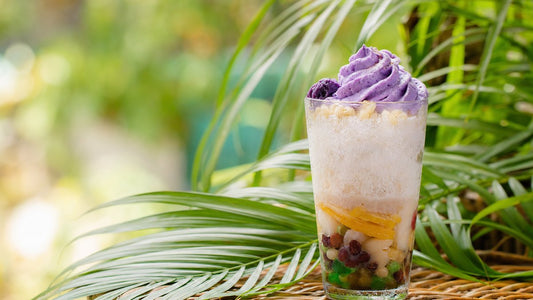 Filipino halo-halo dessert topped with purple ube whipped cream foam in a glass